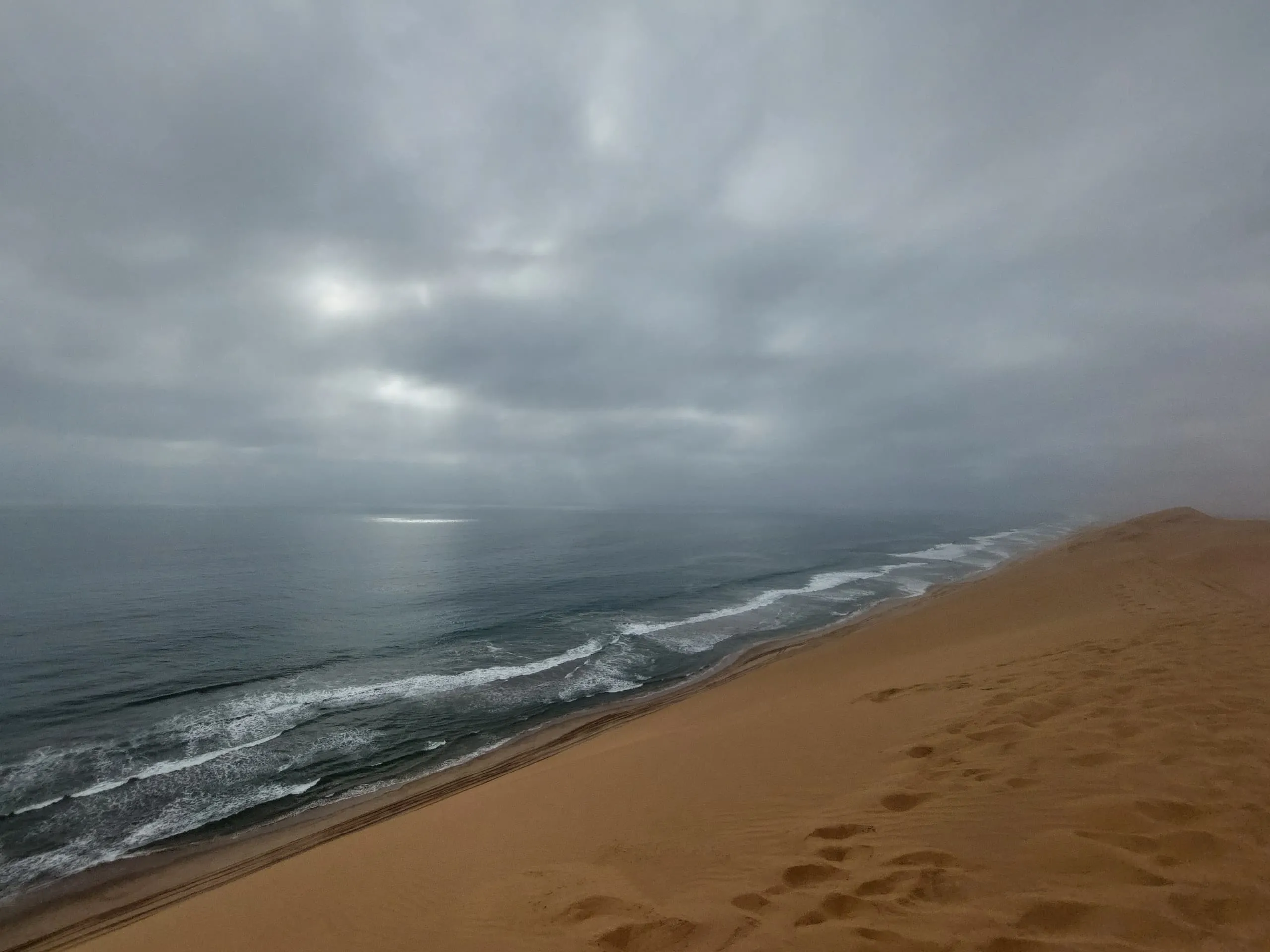 Panoramic view of Sandwich Harbour's unique desert-ocean interface in Namibia