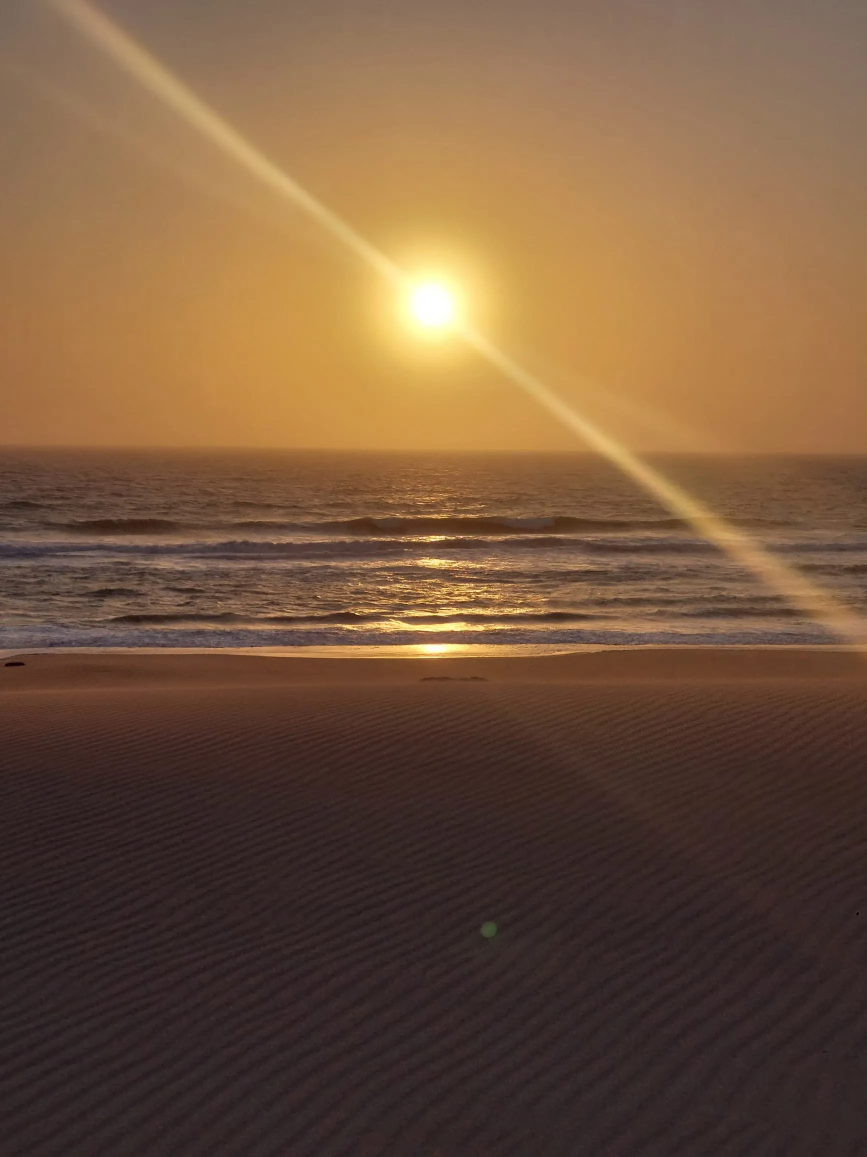 Sunset over the Namib Desert and Atlantic Ocean at Sandwich Harbour, Namibia